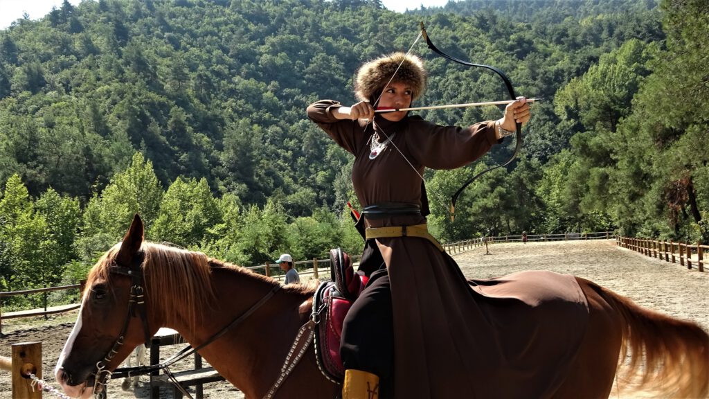 Genç kızlar savaşçı gibi giyinip at üzerinde ok atmayı öğretiyor